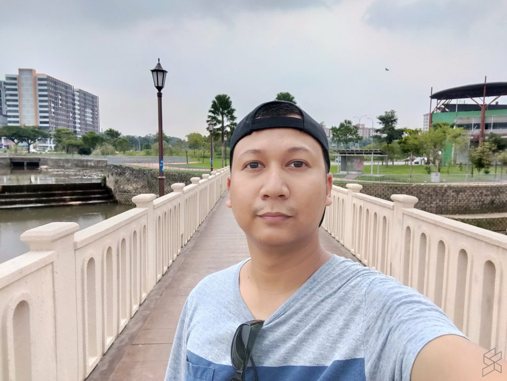 A person with a bridge in the background

Description automatically generated